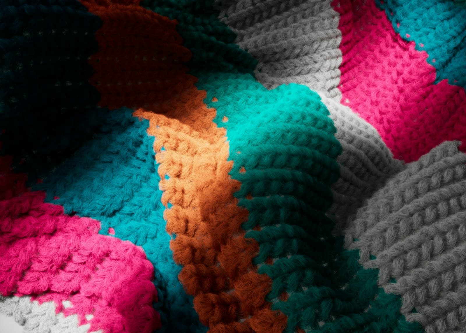 Close-up of a colorful crocheted blanket showing bold color-blocked panels