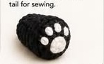 Firmly stuffed black crocheted panda leg with a white paw pad already embroidered onto the foot