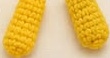 Pair of small yellow crocheted Pikachu arms, thin flattened tubes ready for sewing