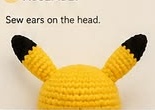 Bare yellow crocheted head with both black-tipped ears sewn on, before the face is added