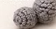 Small firmly stuffed grey crocheted raccoon leg, rounder and wider than the arm piece